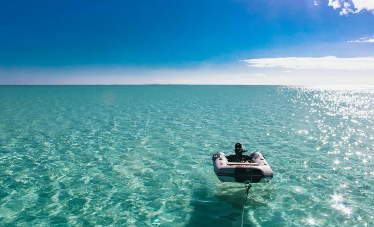 Inflatable dinghy tender with outboard motor on calm turquoise sea